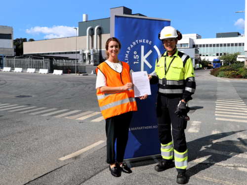 To personer står utenfor nikkelverket med partnerkontrakt