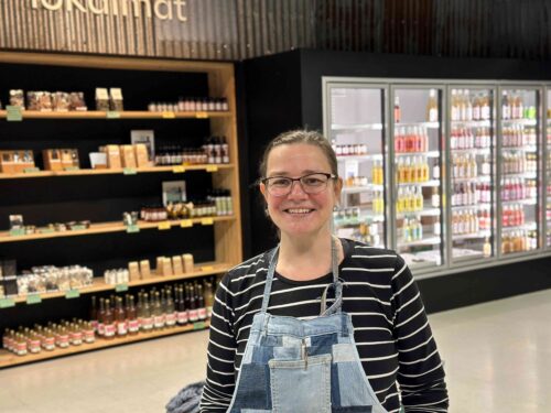 Camila som står foran lokale produkter på Egna.